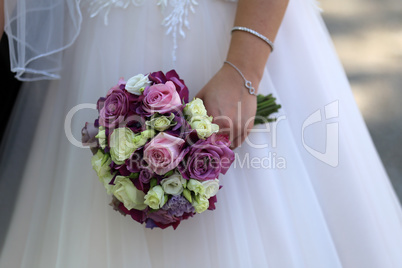 The bride holds a wedding bouquet in her hand