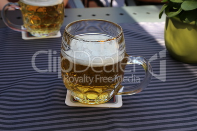Mug of light beer stands on the table