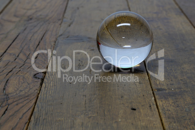 The big glass sphere lies on wooden boards