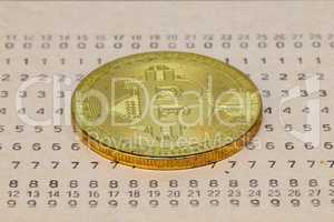 Golden Bitcoin lies on the old punch card