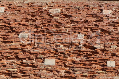 The old red brick fortress wall is crumbling