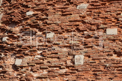 The old red brick fortress wall is crumbling