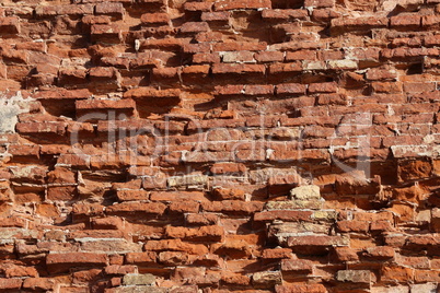 The old red brick fortress wall is crumbling