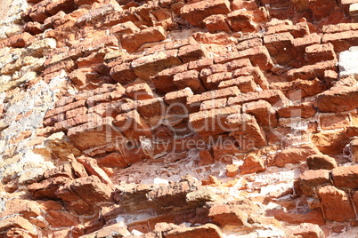 The old red brick fortress wall is crumbling