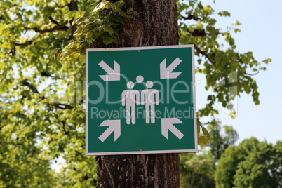 A sign on the tree indicates the gathering place