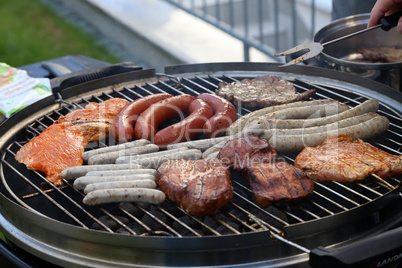 Meat and sausages are fried on the grill