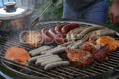 Meat and sausages are fried on the grill