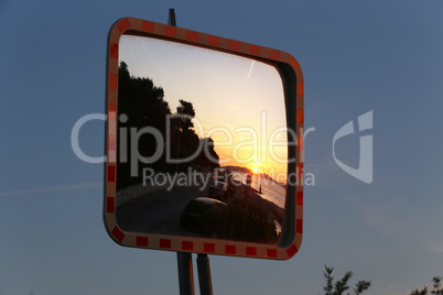 Sunny sunset in the mirror by the road