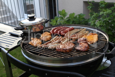 Meat and sausages are fried on the grill