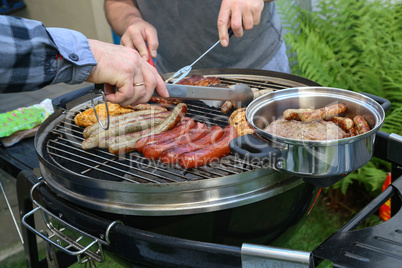 Meat and sausages are fried on the grill