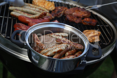 Meat and sausages are fried on the grill