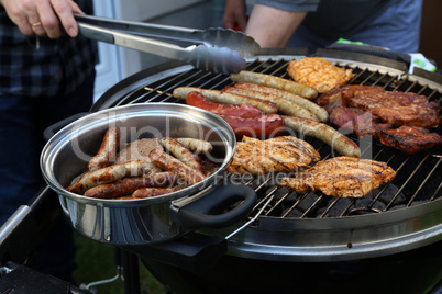 Meat and sausages are fried on the grill