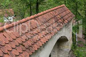 Red flat tile on old stone gate