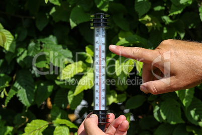 Hot Summer. Thermometer in hand, shows the heat