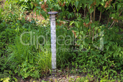 Large street thermometer stands in the garden