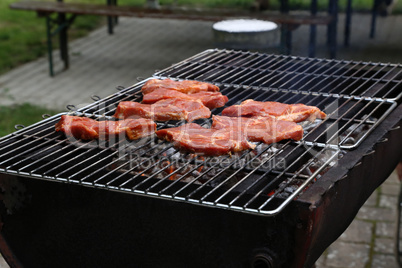Meat and sausages are fried on the gril