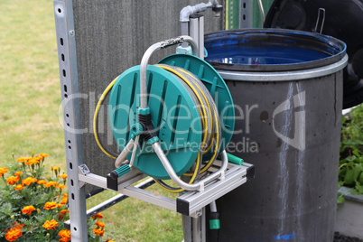 A barrel of water and a watering hose