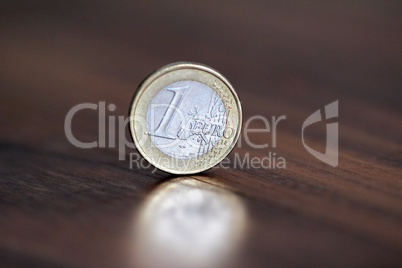 A coin worth one euro, stands on the edge