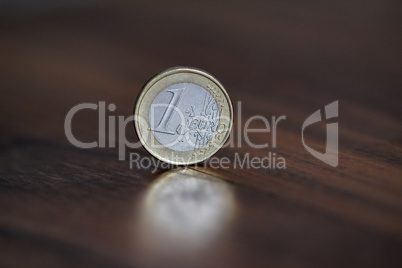 A coin worth one euro, stands on the edge