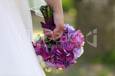 The bride holds a wedding bouquet in her hand