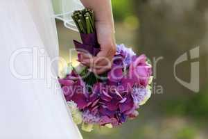 The bride holds a wedding bouquet in her hand