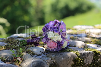 The brides wreath lies on a stone wall