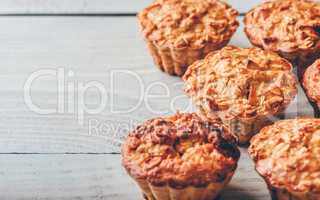 Cooked muffins on wooden background.