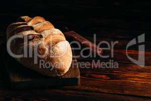 Rye loaf on cutting board with knife.