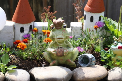 Decorative princess frog by the pond in the garden