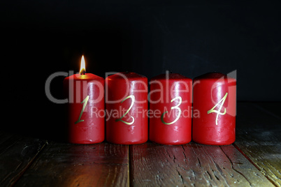 1.Advent. Red Advent candles stand on a wooden floor