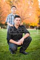 Hispanic Father and Son Portrait Against Fall Colored Trees