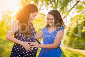 Hispanic Pregnant Mother and Daughter Feeling Belly