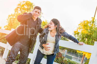 Stunned Hispanic Pregnant Young Couple In Pain Walking Outdoors