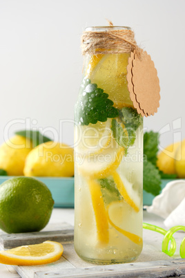 refreshing drink lemonade with lemons, mint leaves, lime in a gl