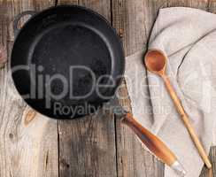 empty black round frying pan with  handle and spoon