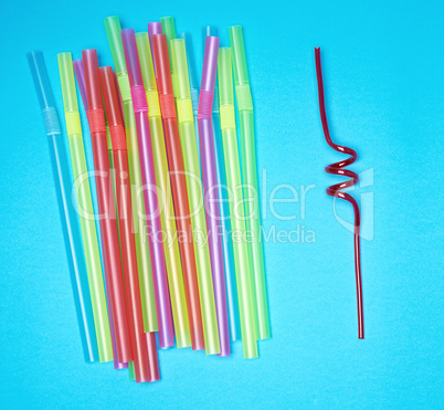 multi-colored plastic tubules for cocktails on a blue background