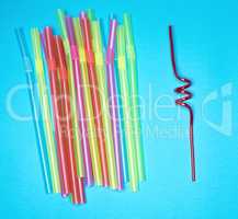 multi-colored plastic tubules for cocktails on a blue background