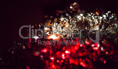 Dark background with tinsel and ball