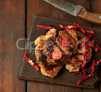 grilled pork pieces of meat on a grill lie on a vintage wooden b