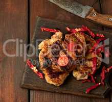grilled pork pieces of meat on a grill lie on a vintage wooden b
