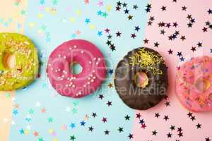 round donuts with various fillings and sprinkles on an abstract