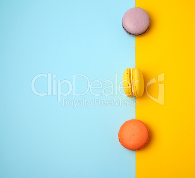 multi-colored baked round macarons on a colored background