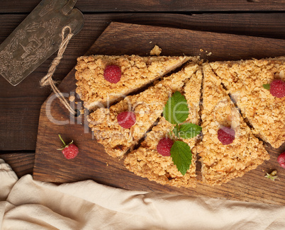 sliced triangular pieces of crumble pie with apples on a brown w