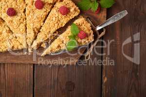 sliced triangular pieces of crumble pie with apples on a brown w