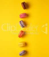 assortment of multi-colored baked round macarons on a yellow bac