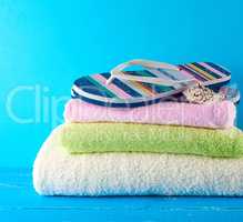 pair of female beach slippers and a towels