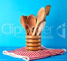 wooden spoons in a wooden container on a blue table
