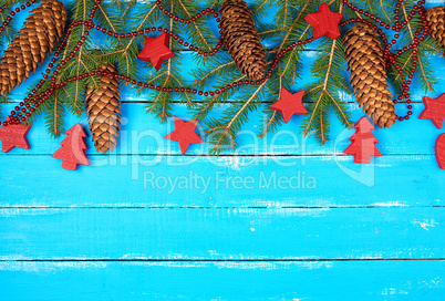 green branches of needles and yellow Christmas garland, red deco