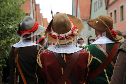 Reconstructors in musketeers clothes on a city holiday