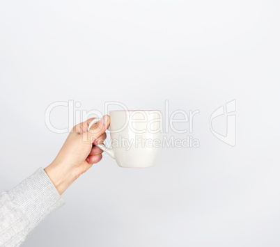 gray ceramic cup in female hand on a white background